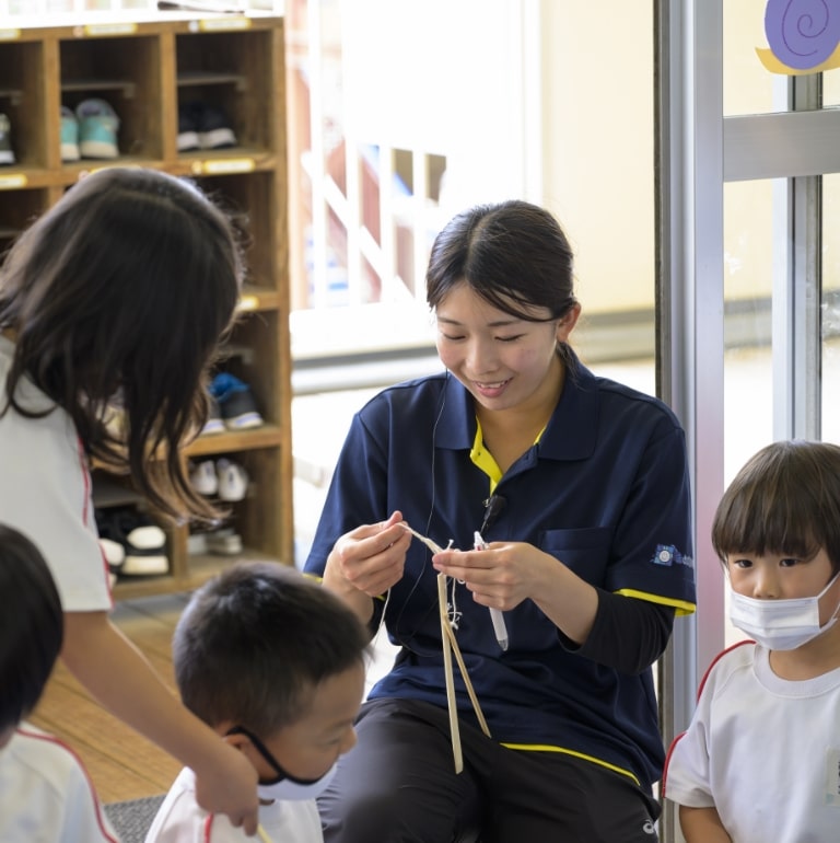 先生たちと子どもたちが楽しそうに制作物を作ってます